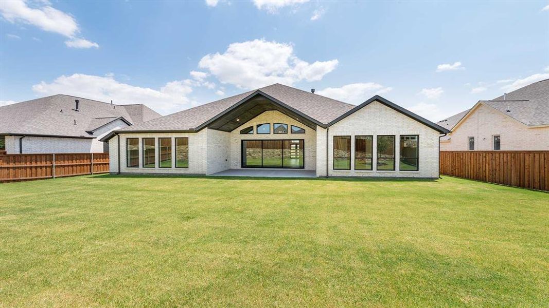 Rear view of property featuring a patio and a lawn