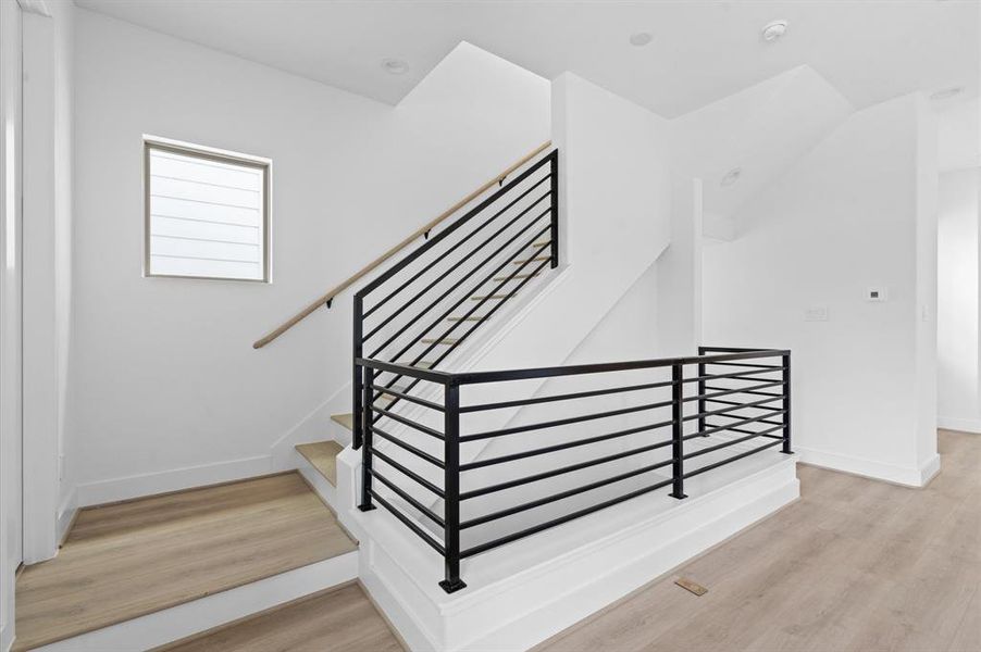 Polished black metal railing ascending to the third floor.