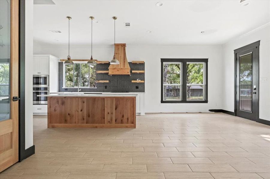 Kitchen with plenty of natural light, hanging light fixtures, a center island, light countertops, and recessed lighting