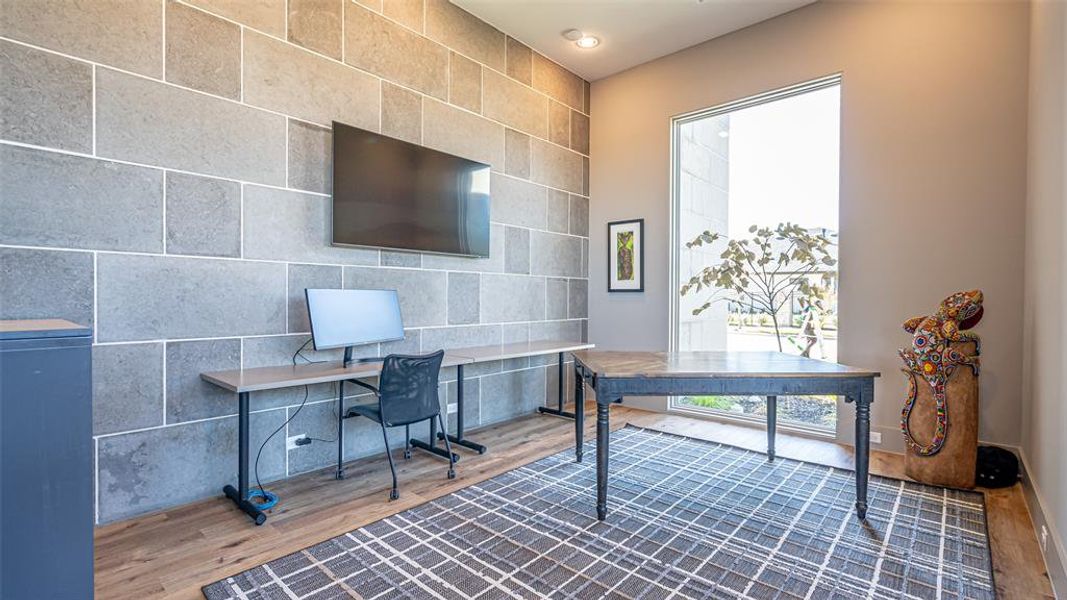 Office area with wood-type flooring and tile walls