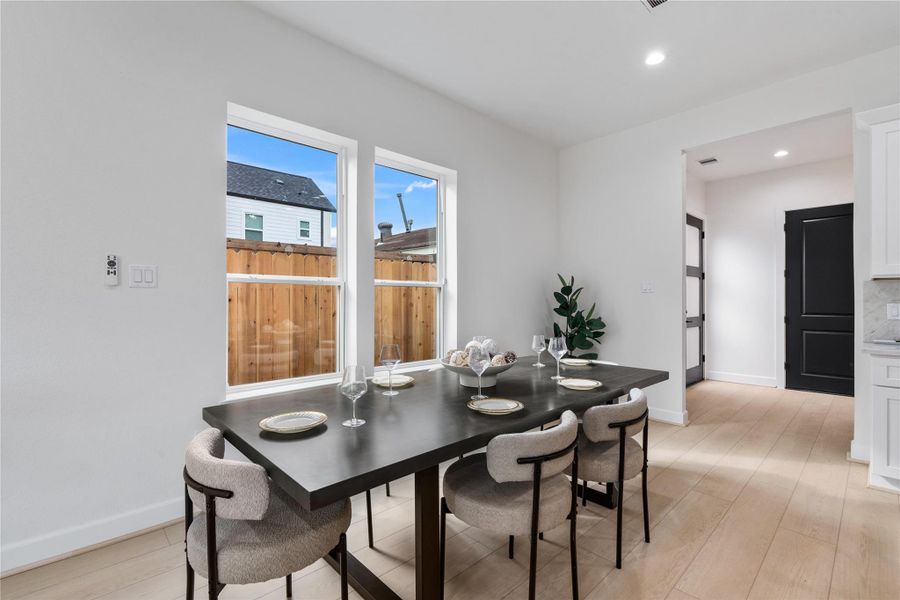 Dining area framed by tall windows that fill the space with natural light. Dining area framed by tall windows that fill the space with natural light.