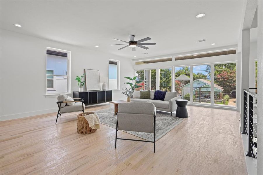 Living room with ceiling fan and light wood-type flooring