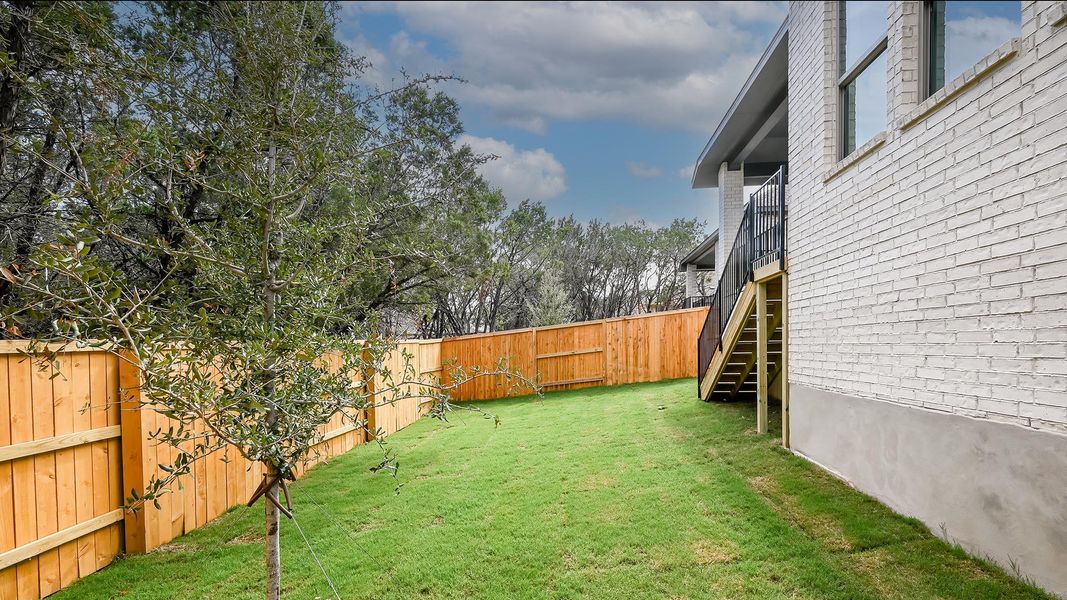 Fenced backyard with stairway and a balcony