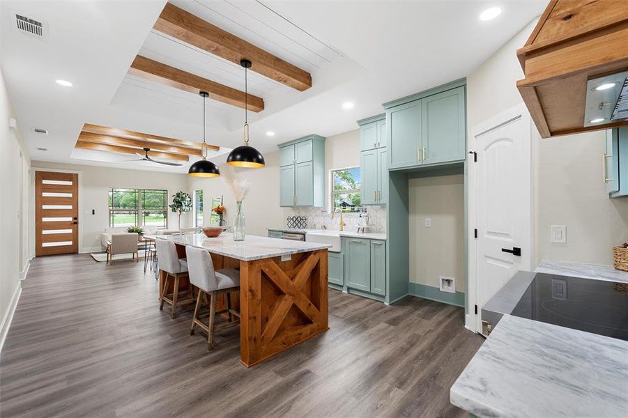 Kitchen featuring a raised ceiling, dark wood finished floors, recessed lighting, backsplash, and beam ceiling