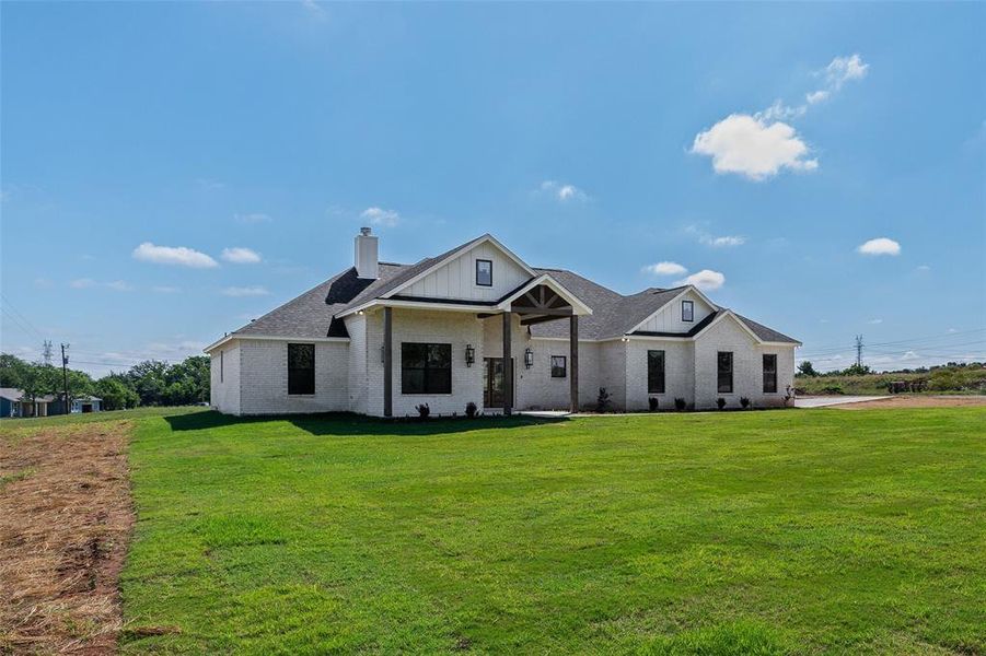 Modern farmhouse exterior featuring white brick and vertical siding accents