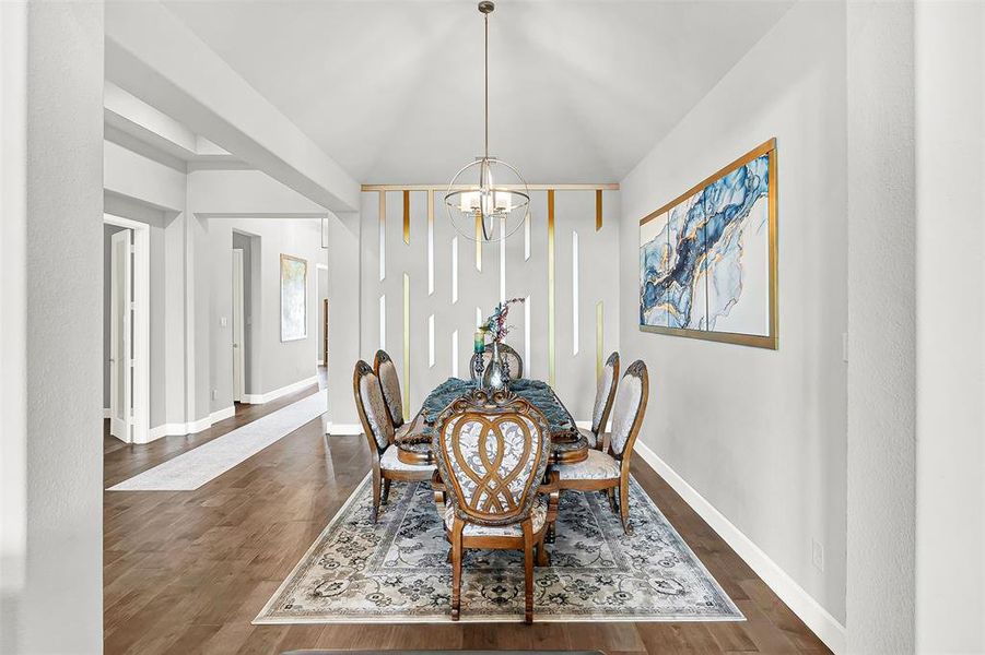 Dining area featuring a chandelier and dark wood-style floors