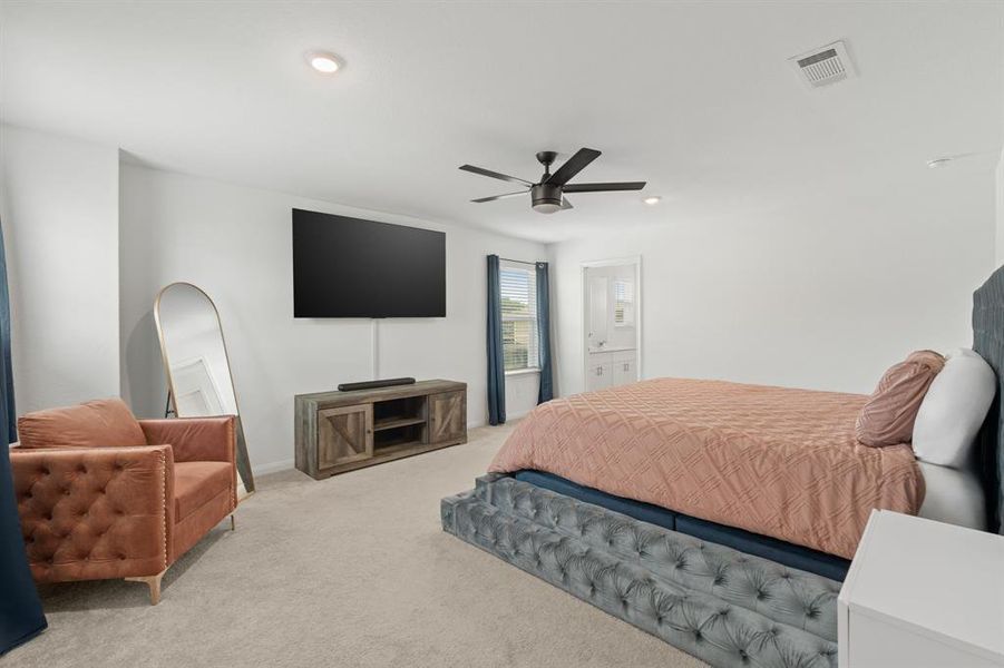 An additional view of the Prestigious Primary Suite which boasts plush carpet, oversized windows to allow in natural light and convenient access to the Primary Bath Oasis.