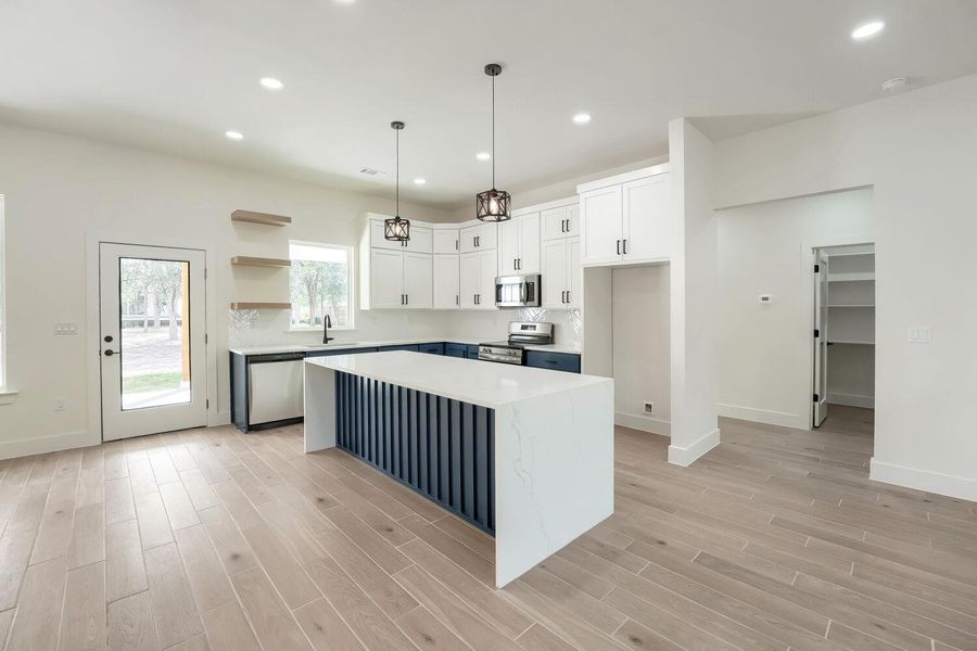 A well-appointed kitchen features a large island and ample cabinetry, offering a bright and functional space.