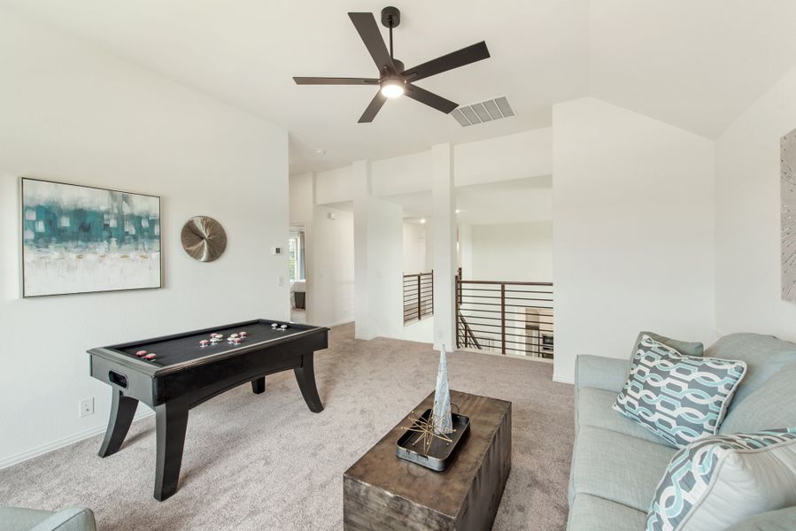 Upstairs game room with air hockey table, ceiling fan, and open railing overlooking lower level Upstairs game room with air hockey table, ceiling fan, and open railing overlooking lower level