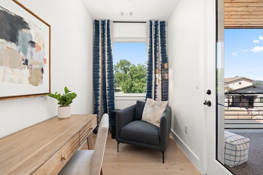 This cozy nook features a small, bright space with a large window offering a scenic view. Ideal for a home office or reading area, it combines functionality with a touch of elegance.