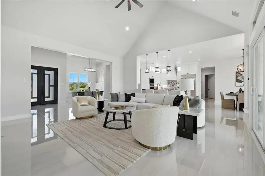 Living area featuring high vaulted ceiling, ceiling fan, and recessed lighting Living area featuring high vaulted ceiling, ceiling fan, and recessed lighting