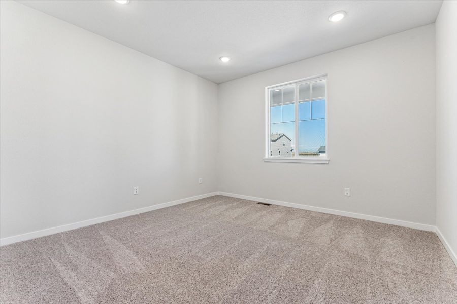 A room with a window and a carpet.