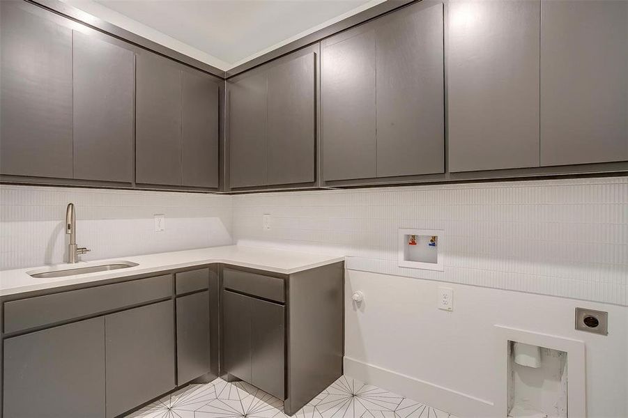 Clothes washing area featuring cabinets, electric dryer hookup, hookup for a washing machine, sink, and light tile floors