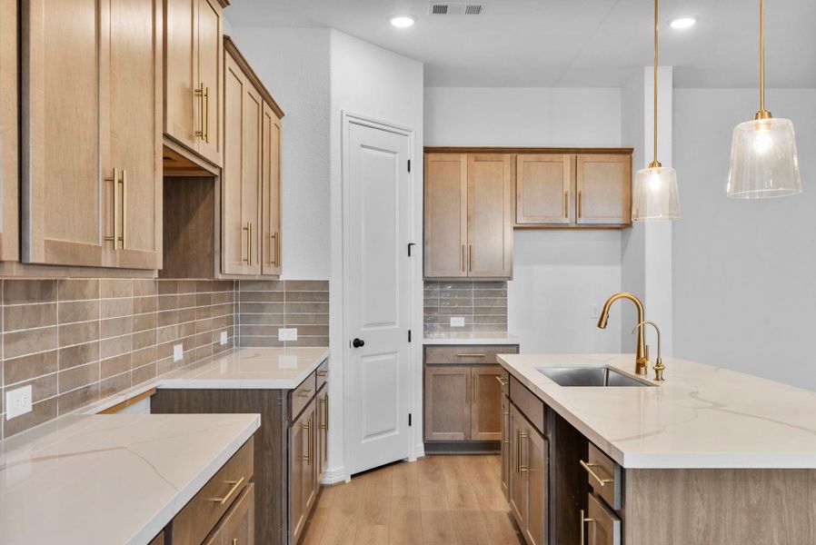 A chef’s dream kitchen with a central island, spacious walk-in pantry, and open connection to the dining area.
