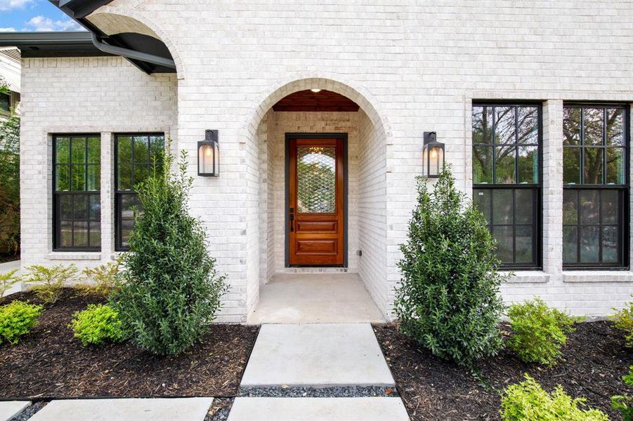 Arched entryway featuring a paneled wood door with a decorative glass insert Arched entryway featuring a paneled wood door with a decorative glass insert