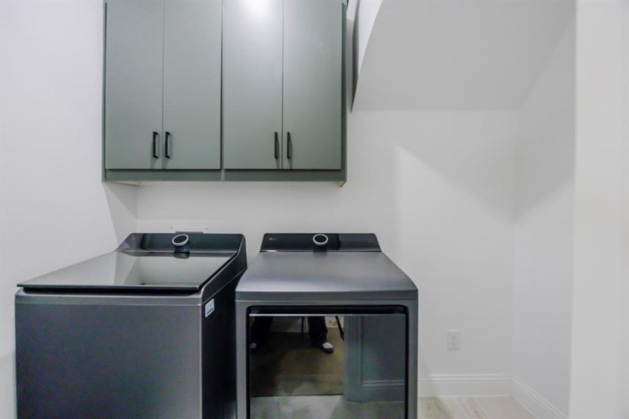 Laundry area with baseboards, cabinet space, and washer and clothes dryer