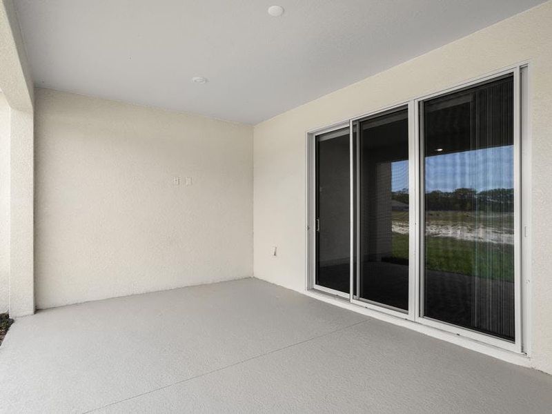 A triple sliding glass door opens to outdoor living space on your covered lanai.