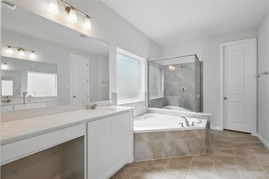 Full bathroom featuring a bath, visible vents, a stall shower, and plenty of natural light Full bathroom featuring a bath, visible vents, a stall shower, and plenty of natural light