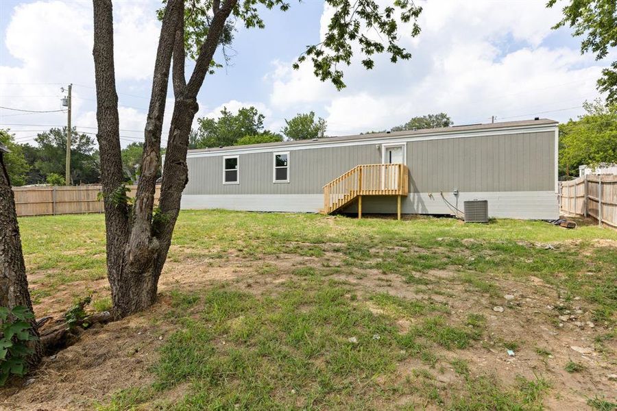 Spacious backyard featuring multiple mature trees and a wooden privacy fence