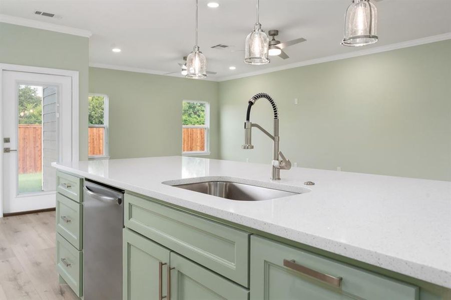 Kitchen with sink, hanging light fixtures, light wood-type flooring, dishwasher, and ceiling fan