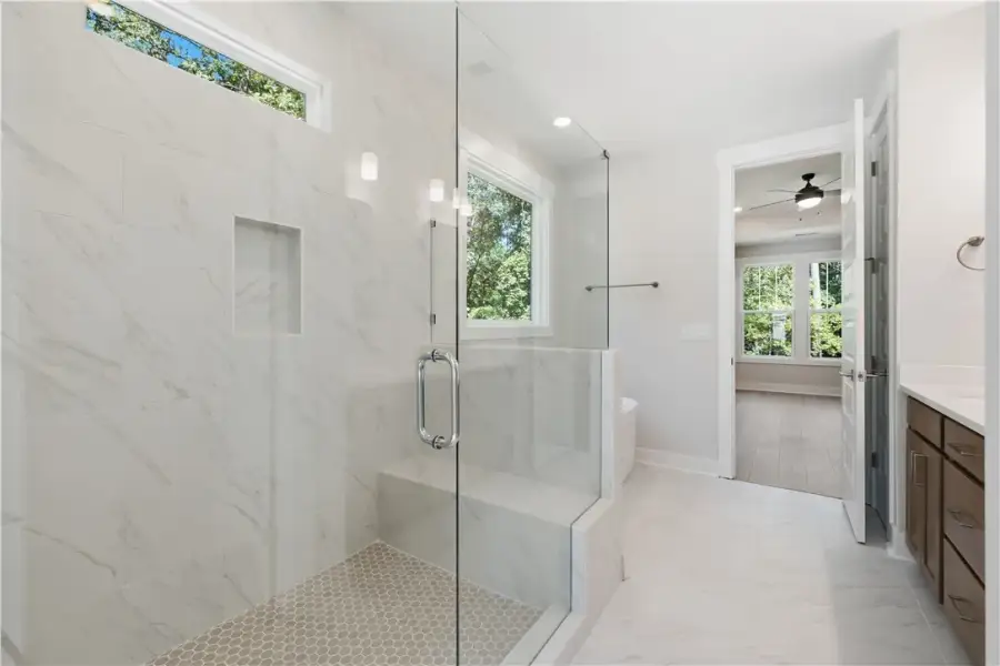An elegant tile shower with a built-in bench ancho