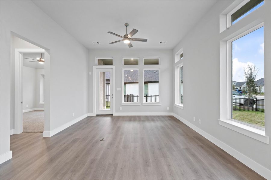 The great room features tall ceilings, ceiling fan, abundant natural light with plenty of windows, and an open, inviting ambiance--perfect for gatherings, relaxation, and making memories.