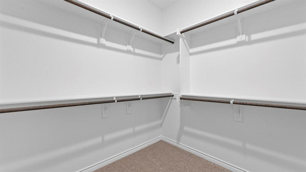 Walk in closet featuring light carpet Walk in closet featuring light carpet