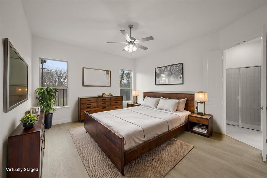The primary bedroom is a retreat to itself. Located at the back of the home away from the activity, this primary bedroom is a peaceful sanctuary. It has views of the backyard and nature area. It is split for privacy. It has a ceiling fan.