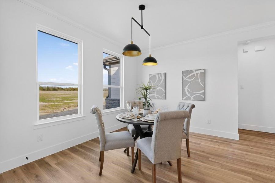 Dining space with ornamental molding and light wood finished floors Dining space with ornamental molding and light wood finished floors