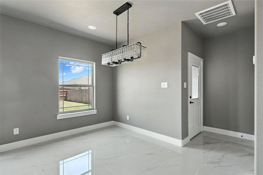 Unfurnished dining area featuring light marble finish flooring and recessed lighting Unfurnished dining area featuring light marble finish flooring and recessed lighting