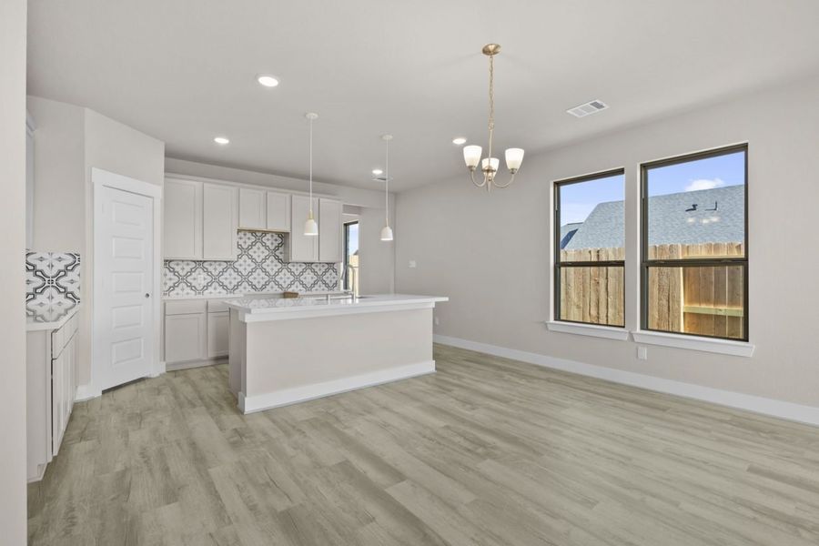 Image of a living room with beige walls, windows with brown trim, and light brown flooring