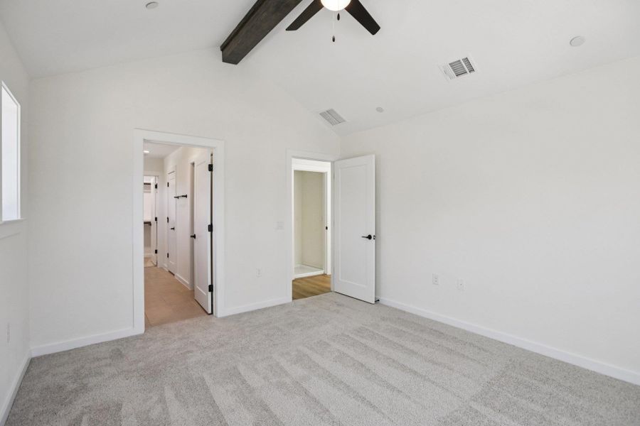 Unfurnished bedroom featuring light carpet, a ceiling fan, and ensuite bath
