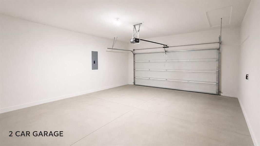 Spacious garage featuring a light concrete floor, bright white walls, and a large overhead door Spacious garage featuring a light concrete floor, bright white walls, and a large overhead door