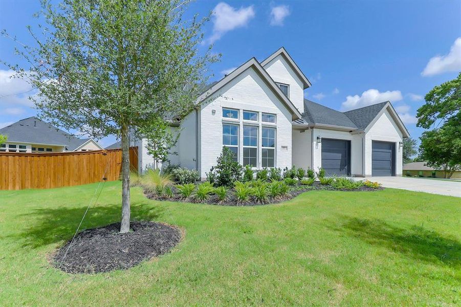 White brick and siding exterior with dark gray garage doors, a multi-pane window, and a dark gray shingle roof White brick and siding exterior with dark gray garage doors, a multi-pane window, and a dark gray shingle roof