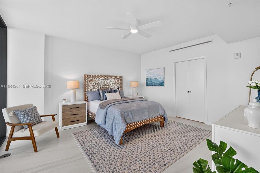 Spacious primary suite with floor to ceiling glass, terrace access, two walk in closets, and spa inspired bath.