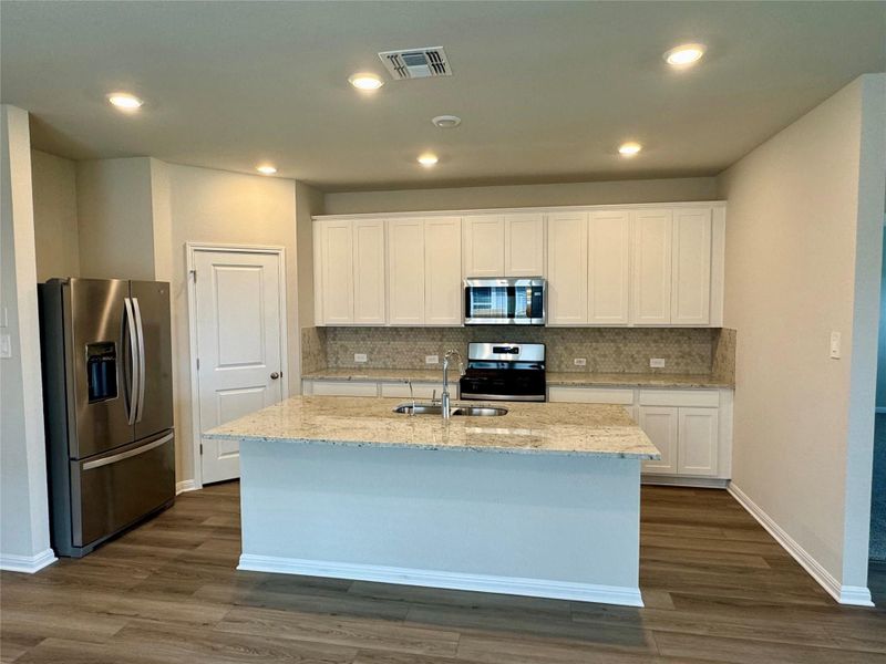 Kitchen featuring stainless steel appliances, dark wood finished floors, white cabinetry, and recessed lighting Kitchen featuring stainless steel appliances, dark wood finished floors, white cabinetry, and recessed lighting