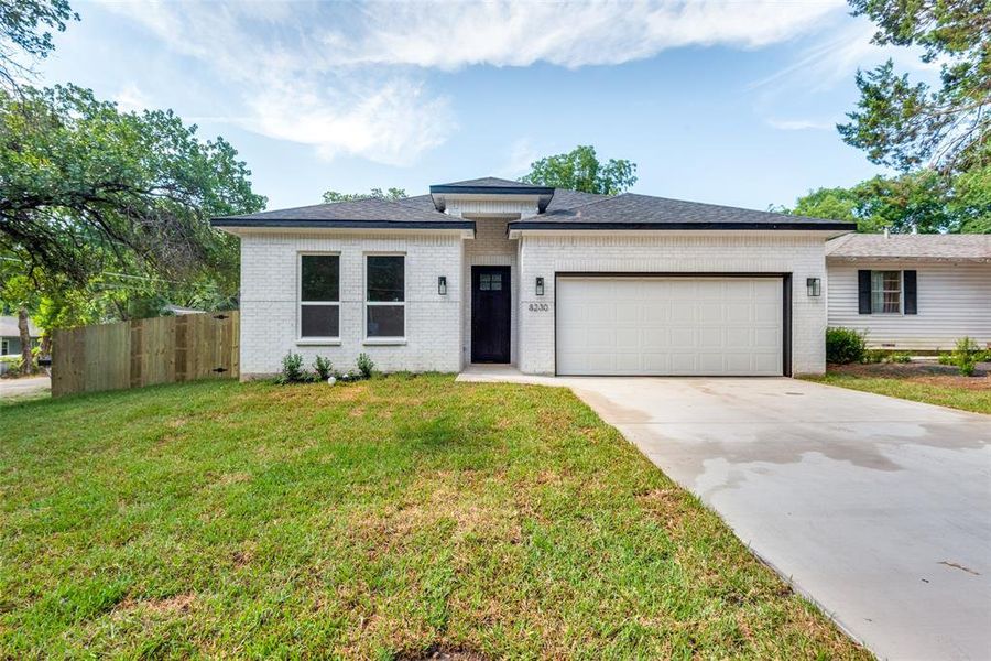 View of front of house featuring a garage and a front lawn