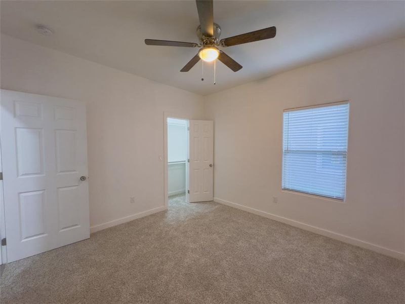 Empty room with ceiling fan and carpet floors