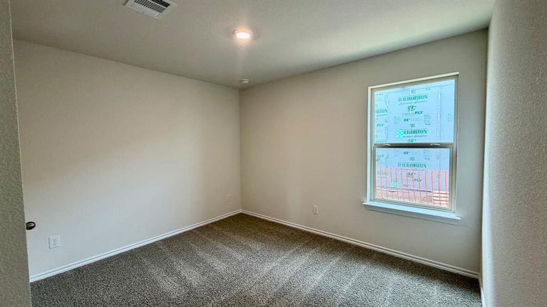 Neutral wall paint with textured carpet flooring