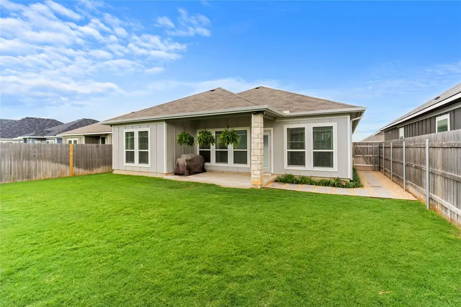 A generous grassy backyard provides ample space for recreation and enjoyment, complemented by a covered patio for outdoor relaxation. A generous grassy backyard provides ample space for recreation and enjoyment, complemented by a covered patio for outdoor relaxation.