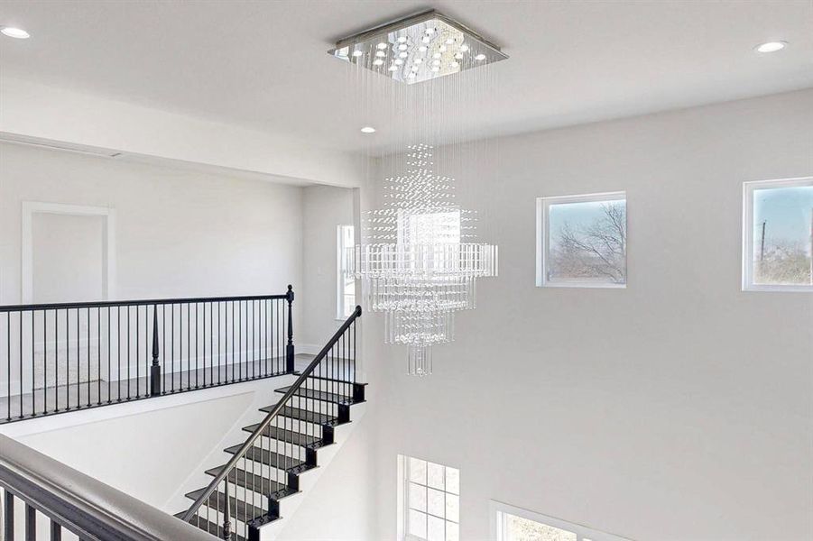 Stairs featuring hanging lights and a high ceiling Stairs featuring hanging lights and a high ceiling