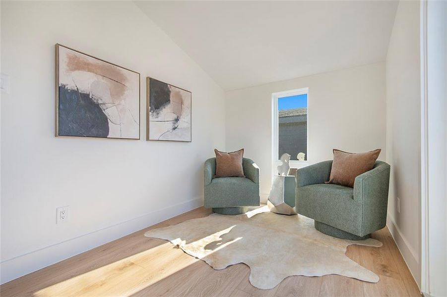 Sitting room with lofted ceiling and wood finished floors Sitting room with lofted ceiling and wood finished floors