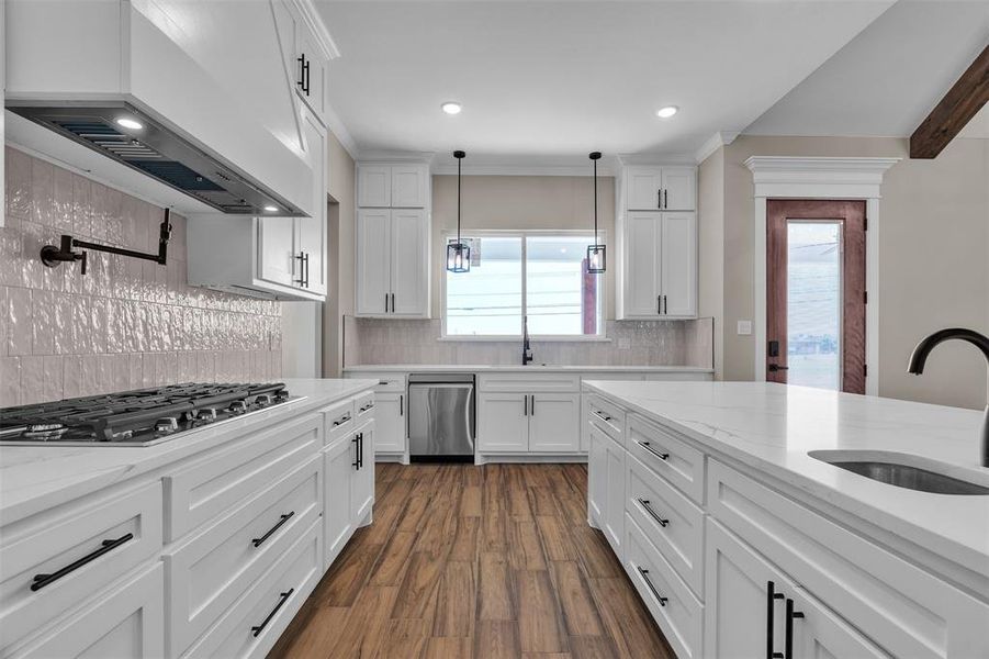 Kitchen with dark wood-type flooring, backsplash, premium range hood, white cabinetry, and recessed lighting Kitchen with dark wood-type flooring, backsplash, premium range hood, white cabinetry, and recessed lighting
