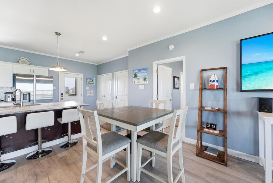 Bright and inviting open-concept kitchen and dining area featuring modern appliances, a sleek island with bar seating perfect for entertaining and family gatherings. Bright and inviting open-concept kitchen and dining area featuring modern appliances, a sleek island with bar seating perfect for entertaining and family gatherings.