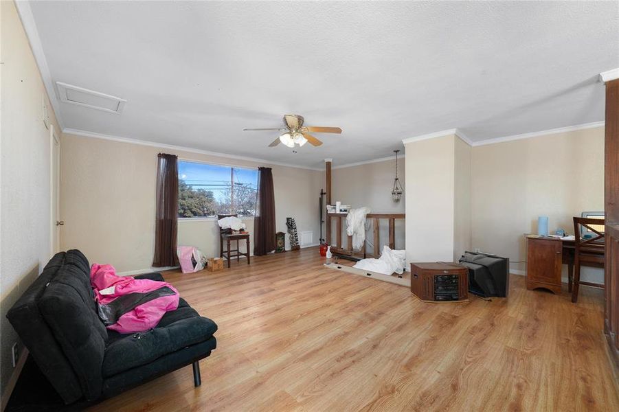 Loft featuring crown molding and light wood-type flooring