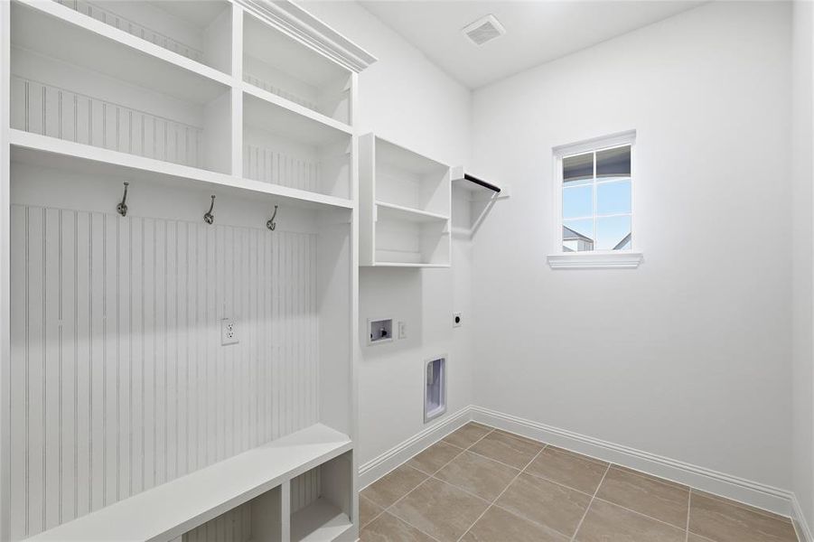 Washroom with hookup for an electric dryer, hookup for a washing machine, and light tile patterned flooring Washroom with hookup for an electric dryer, hookup for a washing machine, and light tile patterned flooring