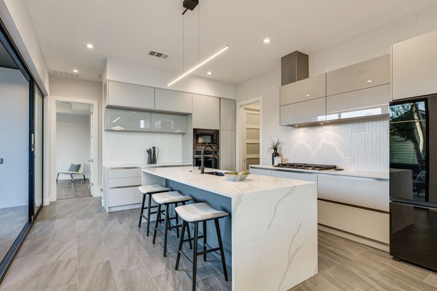 The stainless steel appliances gleam against the backdrop of modern cabinetry and designer fixtures, creating a chic and inviting atmosphere that inspires culinary creativity.