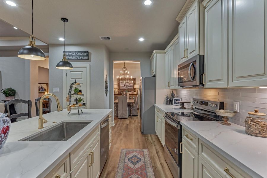 From the kitchen, enjoy a seamless view into the formal dining room. Note the farmhouse-style sink, premium appliances and designer finishes. From the kitchen, enjoy a seamless view into the formal dining room. Note the farmhouse-style sink, premium appliances and designer finishes.