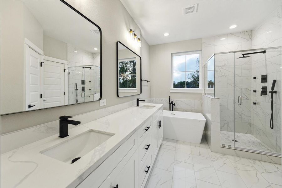 Primary bath features double vanities, soaking tub and walk-in shower