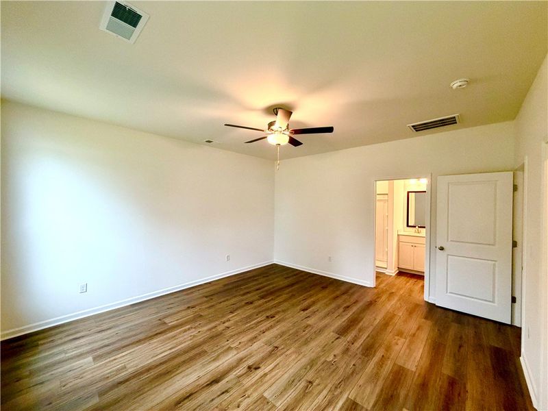 Rich wood-inspired flooring anchors this bedroom f